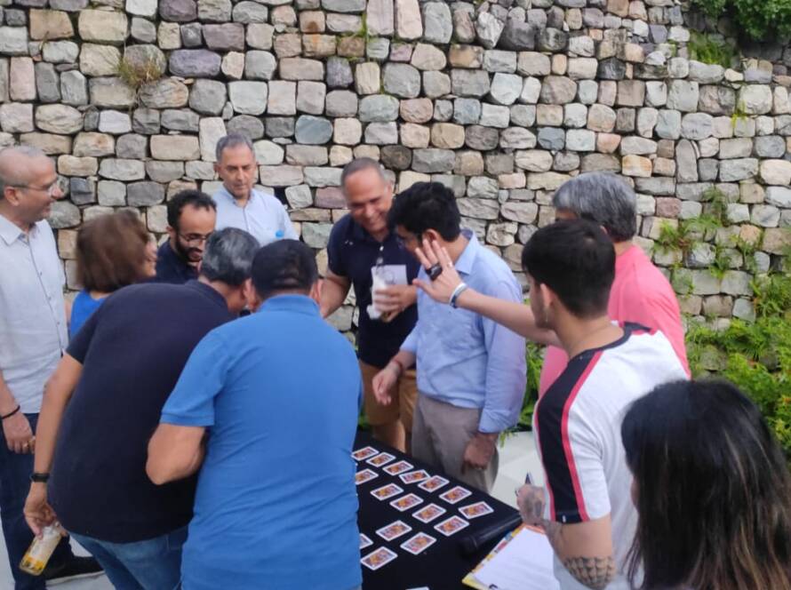 Employees participating in an outdoor team-building game with cones and a ball